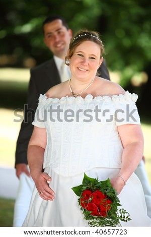 Pregnant little bit chubby bride after the marriage with her husband. groom. Fiance. The Couple is holding each others hand.