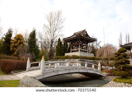 Asian Garden.Temple landscape or landmark with asian style. Japanese Garden with a lot of bonsai, a river and also a bridge. Typical for a chinese garden are the stones and plants.