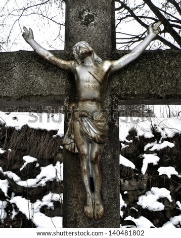 Detail of Jesus Christ on cross in winter time. Statue.