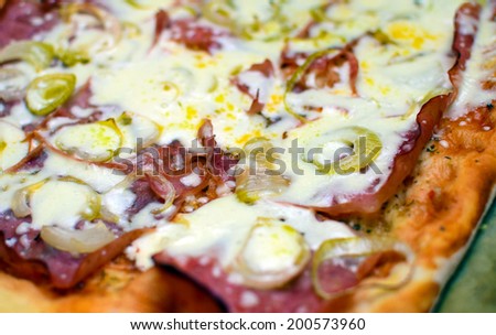 Italian food pizza with ham, tomato, olives, onion and cheese. TV dinner closeup.