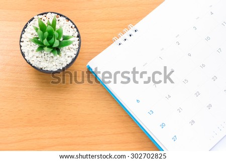 Cactus placed on a wooden table and a beautiful calendar features beautiful place, vintage soft tone