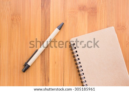 Vintage style of open notebook and pen on the old wooden floor.