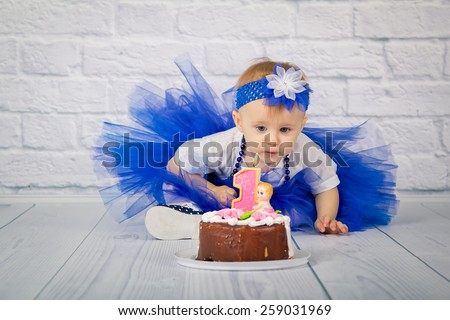 Baby girl and her birthday cake on the floor