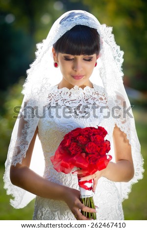 the gentle bride with a bouquet of red roses