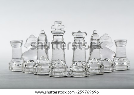 Glass chess pieces in v-shape formation from king and queen.