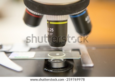 Low power objective of a microscope above slide.