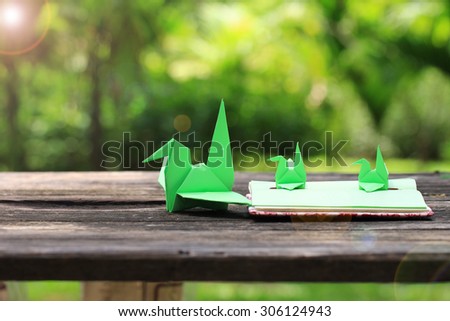 Origami Bird on Handmade notebook, on green background