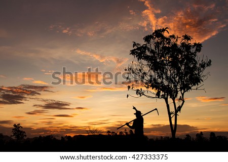 Silhouette of a farmer pointing at orange golden sky. dreaming farmer background. dark tone image.