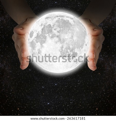 man holding the moon in the hands against the background of the galaxy.\
Elements of this image furnished by NASA
