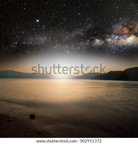 sun on a background star sky reflected in the sea. Elements of this image furnished by NASA