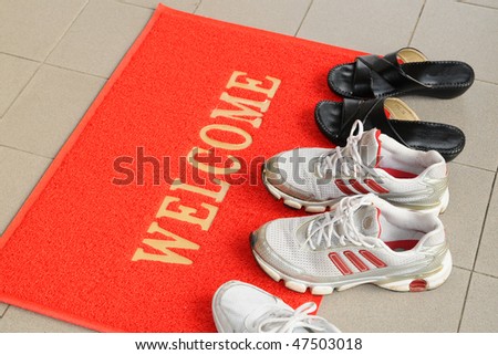 Pairs Of Shoes On A Welcome Mat