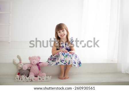 little girl sitting on the steps with toys