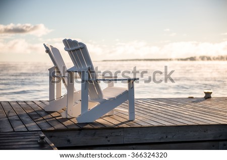 Muskoka chairs on a dock over looking lake Huron and Georgian Bay