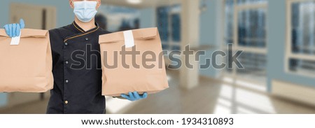 Delivery man holding cardboard packages in medical rubber gloves and mask. copy space. Fast and free Delivery. Online shopping and Express delivery . Quarantine