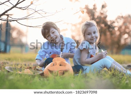 Autumn traditions and preparations for the holiday Halloween. A house in nature, a lamp made of pumpkins is cut out at the table.
