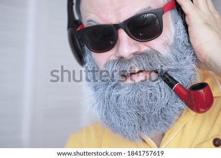 Guy smoking tobacco pipe. Hipster grey beard and mustache. Bad habits conce
