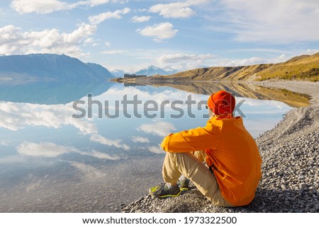 A man is resting at ease by the calm lake. Relaxation vacation