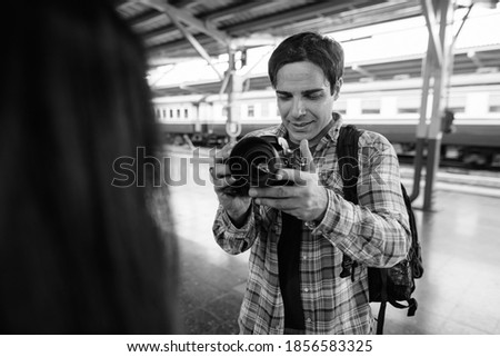 Persian tourist man and young Asian tourist woman together at the railway station