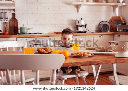 little cute boy in chair on kitchen in morning, lifestyle people concept