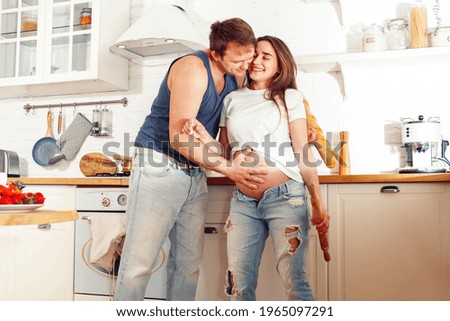 young caucasian couple together having fun on kitchen, woman pregnant, lifestyle people concept