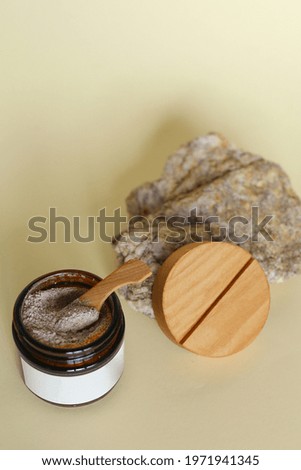 Body scrub of ground coffee, sugar and coconut oil in glass jar on table, homemade cosmetic for peeling and spa care
