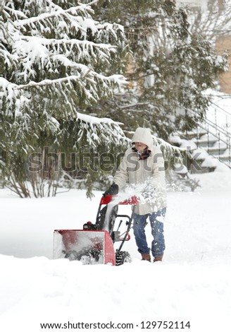 MADISON, WI - FEB 27: A man clears a sidewalk with a snowblower as winter storm Rocky brings more snow to the mid-west on February 27, 2013 in Madison, WI.