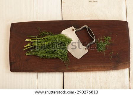 Dill herb being prepared on a cutting board.