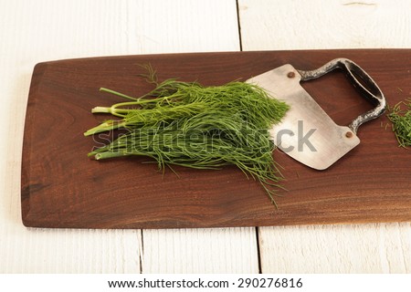 Dill herb being prepared on a cutting board.