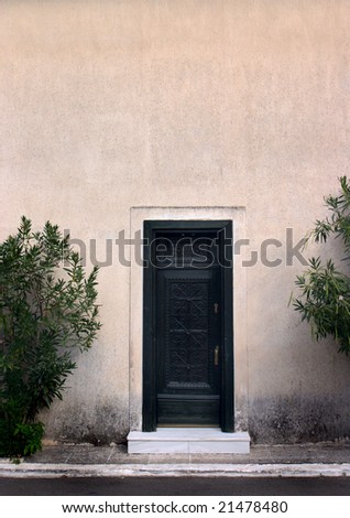 Black door in the center of a pink wall
