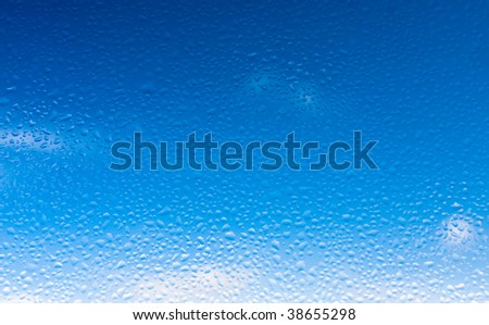 Blue sky through window with water drops