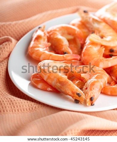 Heap of frozen shrimps on the oval plate, closeup