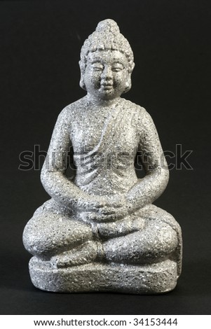 Buddha sculpture in lotus position over black background
