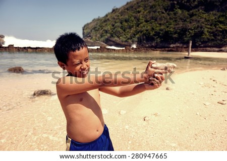 little boy posing as police on the beach