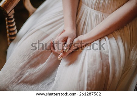 hands of the bride, white dress, bride sitting on a wooden chair