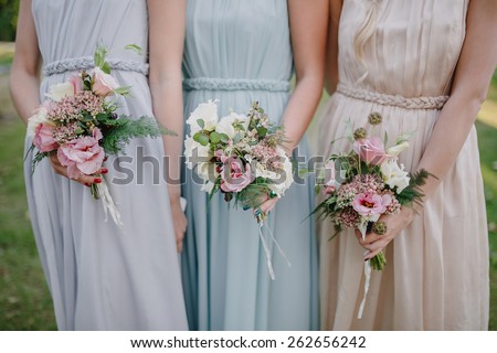 bridesmaid dresses in pastel are holding bouquets in a rustic style