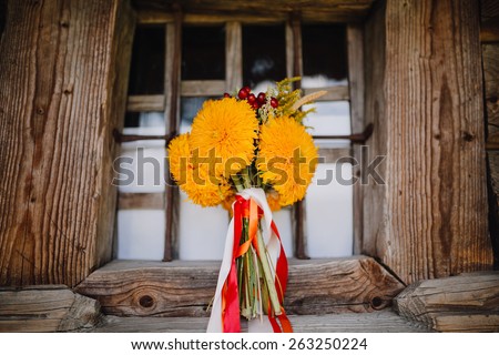 bridal bouquet in the national style in the window of an old wooden house