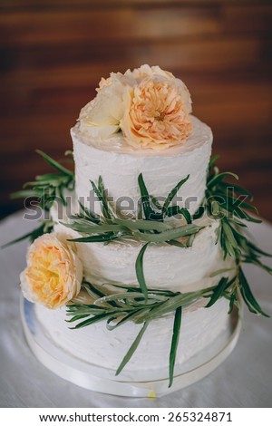 white wedding cake decorated with yellow flowers and green leaves
