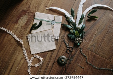 hairpin feather, vintage scissors, pins, parchment envelope with a wax seal on the floor of the old oak boards