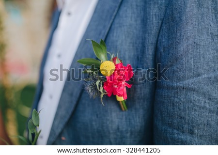 guy in a blue shirt and jacket with bright colors of the buttonhole on the chest