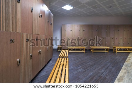 Interior of gym locker room. Luxury and clean dressing room with wooden benches