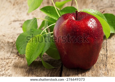 Red apples with water drops on a wooden table, selective focus