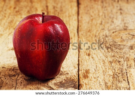 Red apples with water drops on a wooden table, selective focus