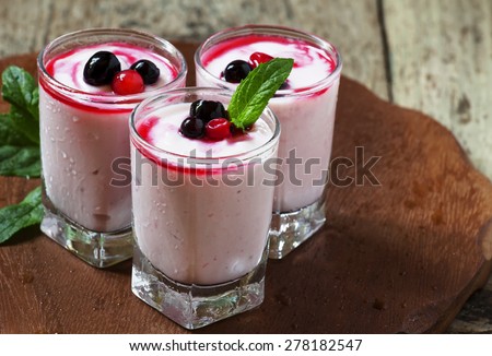 Homemade yogurt with berry juice and currants in a glass, selective focus