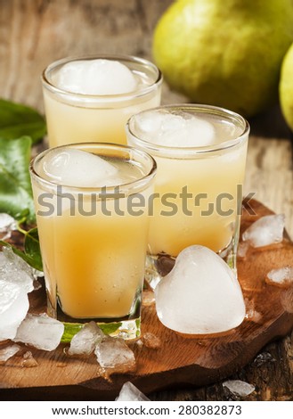 Pear fresh juice with ice in a heart-shaped and pear on a wooden table, selective focus