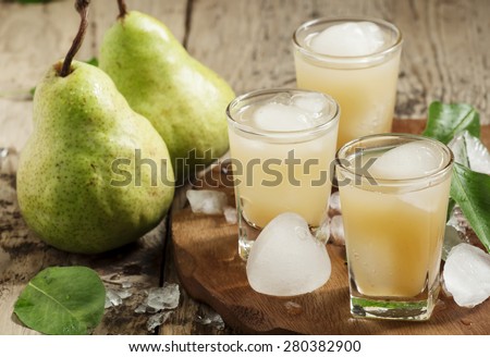 Pear fresh juice with ice in a heart-shaped and pear on a wooden table, selective focus