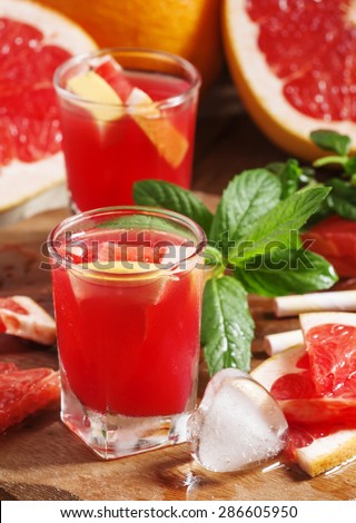 Fresh juice of red grapefruit pulp, ice and citrus slices, selective focus