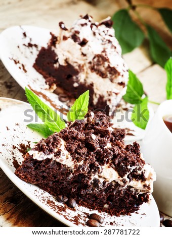 Chocolate and coffee cake with butter cream and mint with a cup of coffee, selective focus