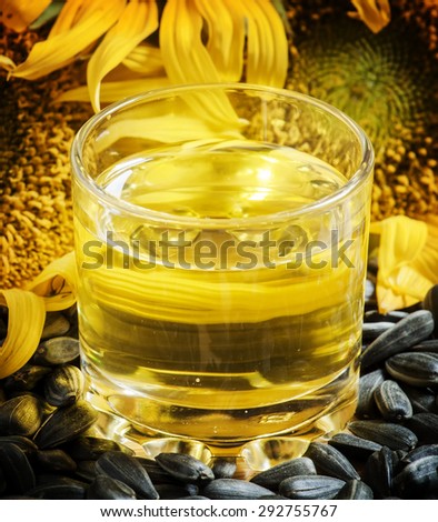 Fresh sunflower oil in a glass with flowers sunflowers and sunflower seeds, selective focus