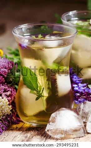 Herbal flower iced tea with ice in Islamic glasses, toned, selective focus