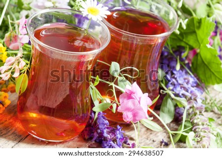 Black tea with  herbs in an authentic Middle Eastern glasses on an old wooden table, selective focus